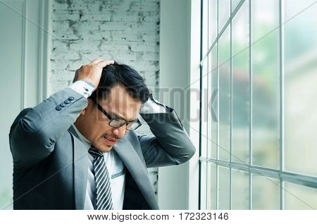 Businessman haedache and heart failure when he work hards at his offiice.