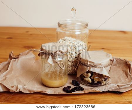 real comfort wooden kitchen with breakfast ingredients close up in glass, honey, oatmeal, milk, muesli, morning food concept