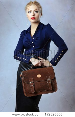 fashion model holding brown bag shot in light background in studio