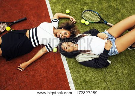 young pretty girlfriends hanging on tennis court, fashion stylish dressed swag, best friends happy smiling together lifestyle