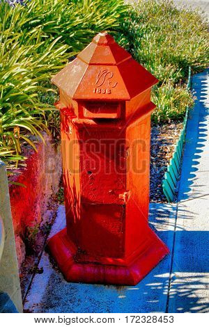 A red 1896 old British style mailbox