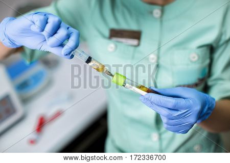 beautician is gaining the blood in the syringe from the tube test. Preparation of blood to the procedure Plasmolifting