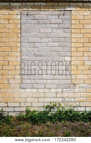 Old gungy white brick wall with bricked up window
