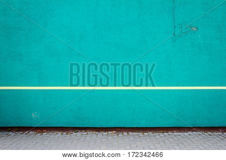 Vibrant cyan plaster wall with single yellow line