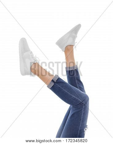 Female feet in sneakers raised up. Isolated on white background.