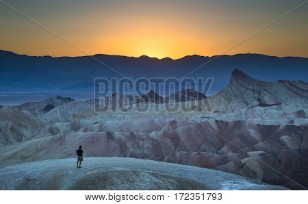Man Enjoying Sunset At Famous Zabriskie Point, Death Valley National Park, California, Usa