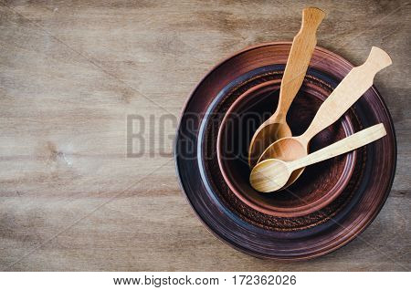 Rustic Kitchen Utensils: the Ceramic Plates and Wooden Cutlery on Wooden Background. Home Wares. Kitchen Decor in Rustic Style. View From Above With Copy Space.