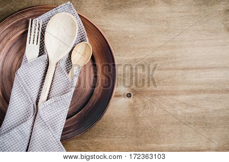 Rustic Kitchen Utensils: the Ceramic Plates and Wooden Cutlery on Wooden Background. Home Wares. Kitchen Decor in Rustic Style. View From Above With Copy Space.