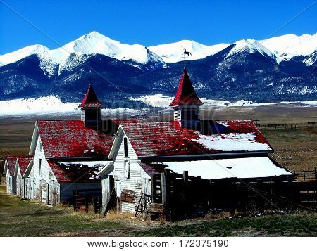 Red and white abandoned barns in Westcliff, Colorado
