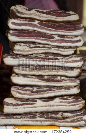 Home made smoked bacon in a street market selective focus and small depth of field
