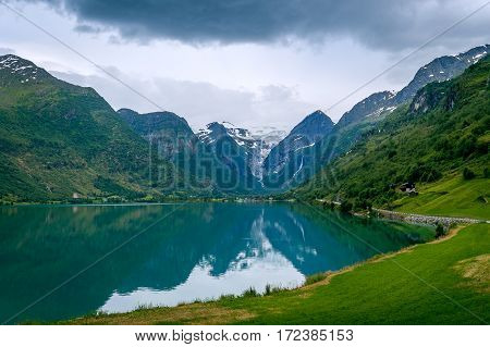 Oldevatnet fjord and view to the rocks of Briksdalsbreen glacier. National touristic route of Norway.
