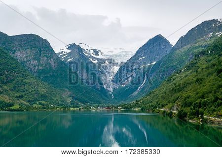The Briksdal glacier and rocks view from the fjord water. Popular touristic attraction, Briksdalsbreen, Norway.