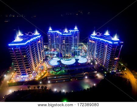 ALANYA, TURKEY - AUG 16, 2015: Three buildings of apartment complex Azura Park Residence with color light at night, aerial photo