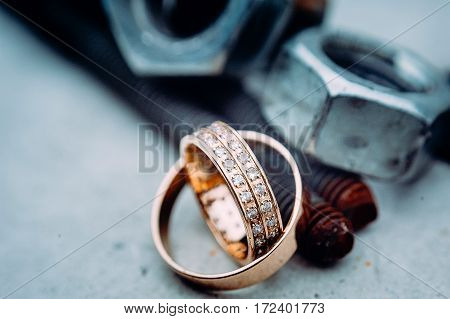 Macro Of Wedding Rings With Diamods On Grey Concrete In Day Light