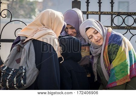 ISTANBUL TURKEY - DECEMBER 27 2015: Turkish young women wearing islamic headscarf listenning to a smartphone in group