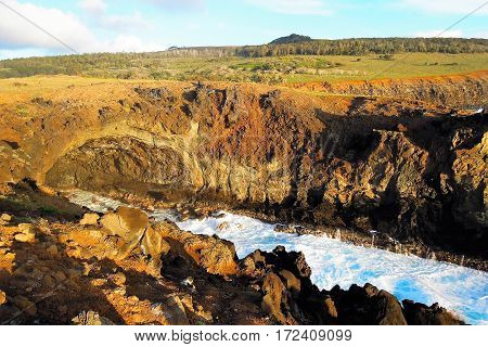 Waves breaking at the cliffs in front of the Ana Kai Tangata Cave close to Hanga Roa in Rapa Nui Easter Island in Chile South America