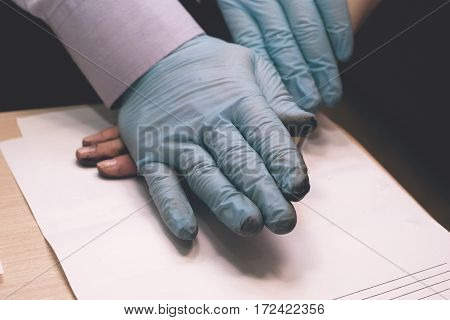 The police officer takes a fingerprint of the suspect in the crime. Investigation of the crime. Guilty of an offense is subject to a policeman's request.