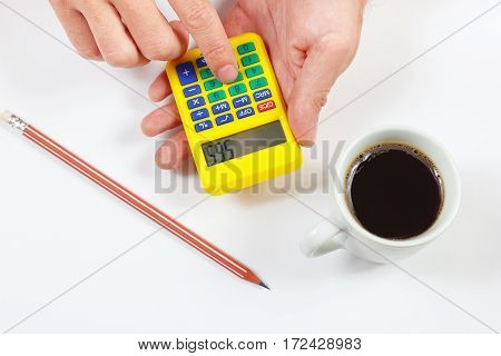 Hands calculate using a pocket calculator on a white background