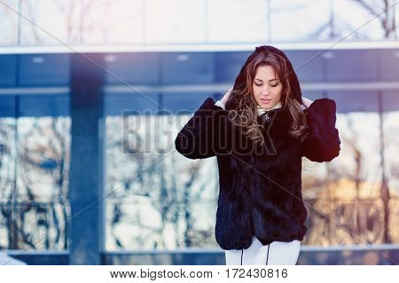 beautiful young woman in a fur coat dress hood.