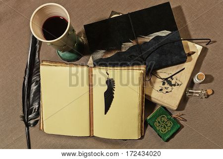 Working place of ancient writer with a cup of wine old books quill and other mystic accessories