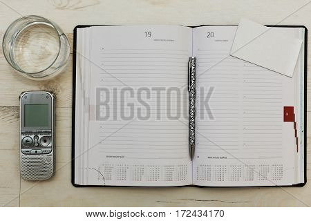 Still life with interview accessories - notebook dictaphone and a glass of water