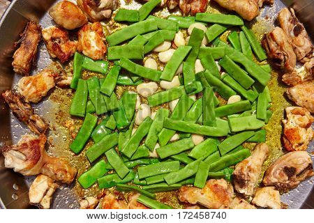 Paella from Spain recipe process ad vegetables green beans and garrofon