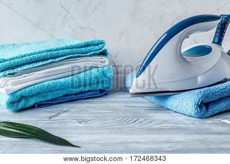 Launry washing set with blue towels and iron on gray desk background mock-up