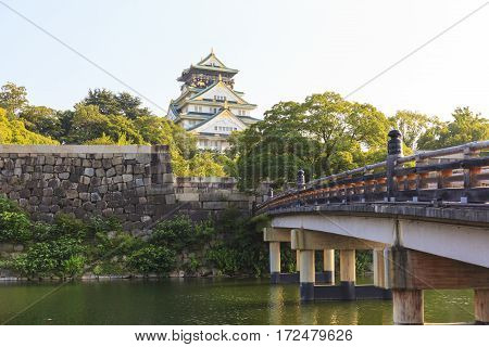 Osaka Castle with wooden Gokurakubashi Bridge in front of the castle during summer season this castle is very famous tourist attraction of Osaka Japan.