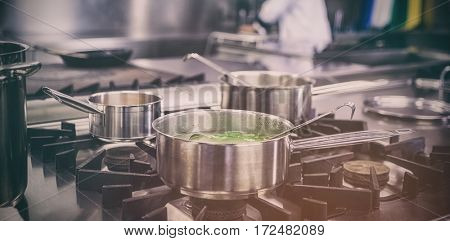Different pots cooking on hotplate in professional kitchen