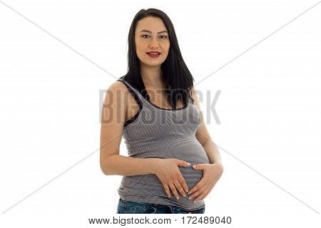 a young pregnant woman holding up hands for the stomach isolated on white