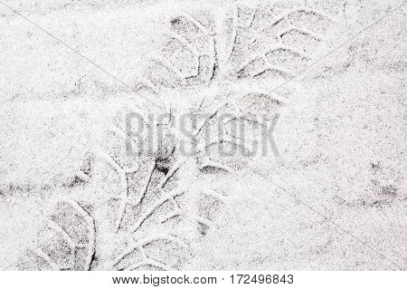 Diagonal traces of car tires on the snow. Close up view from above