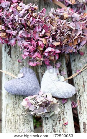 Two tweed hearts with a hydrangea wreath on a shabby chic bench