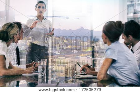 Businesswoman giving explication in front of a growing chart on a whiteboard during a meeting