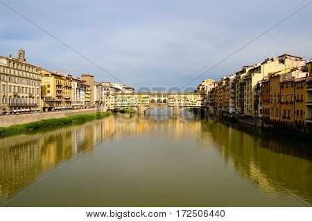 View of medieval stone bridge Ponte Vecchio and the Arno River from the Ponte Santa Trinita (Holy Trinity Bridge) in Florence, Tuscany, Italy.