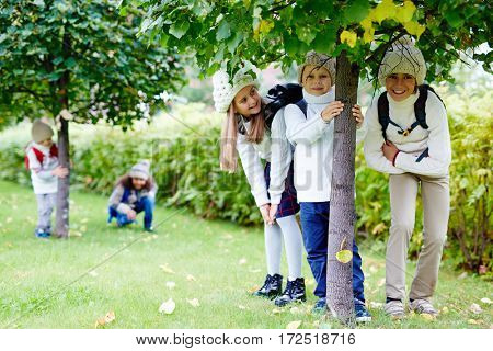 Group of friendly kids standing under linden tree