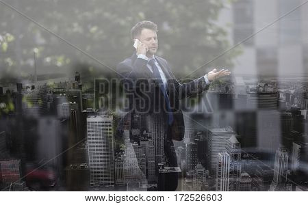 Confused businessman communicating on mobile phone at street