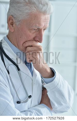 portrait of pensive senior male doctor with stethoscope
