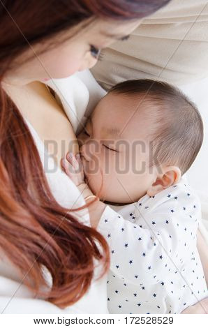 Six months old asian baby drinking breastmilk