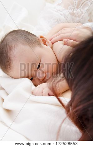 Six months old asian baby drinking breastmilk