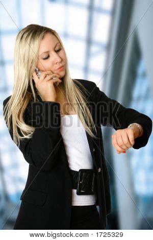 Rubia empresaria en el teléfono móvil en Interior corporativo