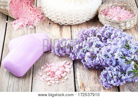 Spa background with blossoming lilac flowers cosmetic aroma soap sea salt and accessories