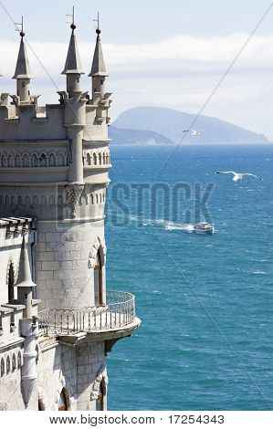 Die Burg auf dem Felsen am Meer mit Möwen darauf