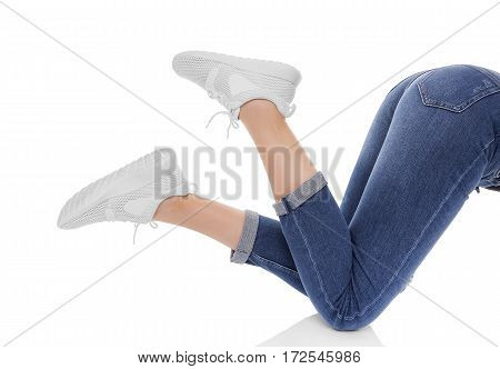 Female feet in sneakers raised up. Isolated on white background.