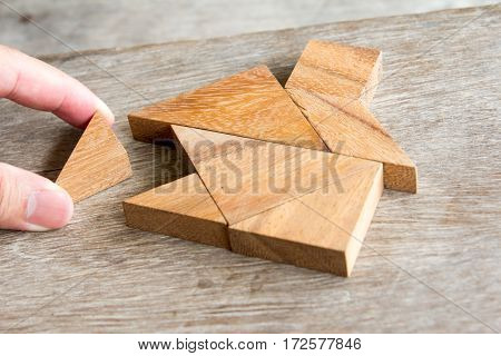 Wooden tangram puzzle wait to fulfill home shape for build dream home or happy life concept