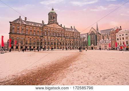 Snowy Damsquare in Amsterdam the Netherlands in winter at sunset