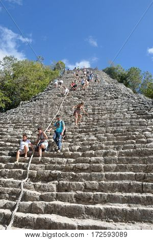 Coba Mexico - January 19 2017: Tourists climbing Temple at Coba Yucatan Mexico