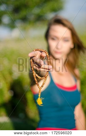 A focus on a yoga mala beads in a girl's hands. Yoga accesoires.