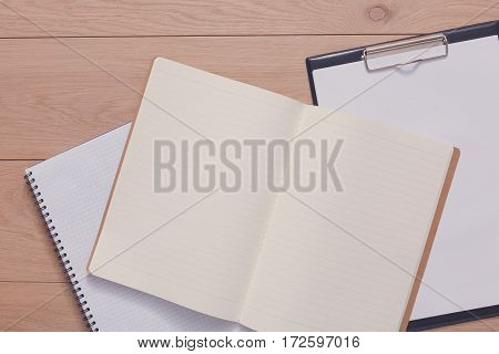 Notepad and personal diary or organizer with pen. Office or student's devices on modern wooden desk. Working table top view. Education or job background with copy space on paper sheet