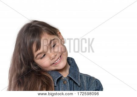 Portrait of long haired brunette little girl isolated on the white background. The girl has her head tilted and is looking into free place ready for your text.