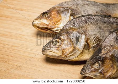 Salty dry river fish to beer on a wooden table. Macro shot.
